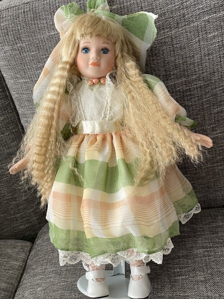 A porcelain doll with a stand.