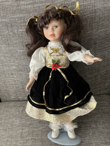 A porcelain doll with a stand.
