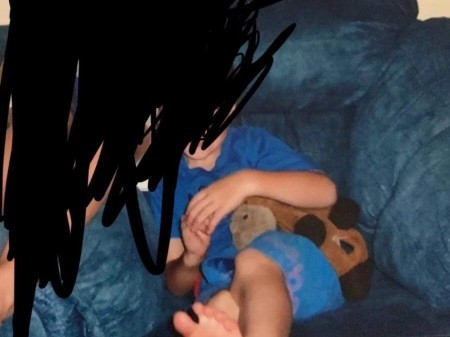 A child holding a brown stuffed horse.