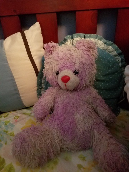 A pink teddy bear with a red nose.
