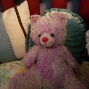 A pink teddy bear with a red nose.