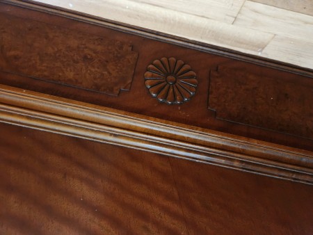A wooden decoration on the bed frame.