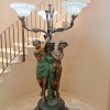 A vintage metal lamp with women figurines.