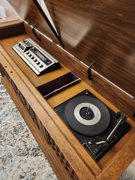 The record player and controls of a console stereo system.