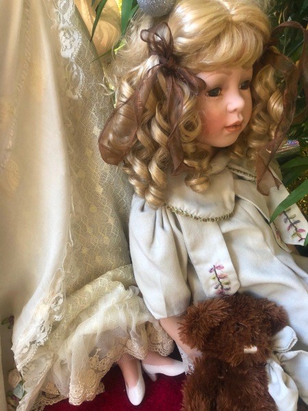 A porcelain doll sitting down.