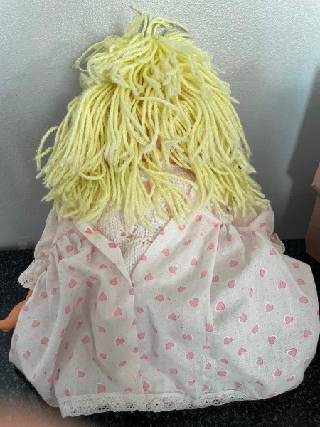 The back of a doll with yarn hair.