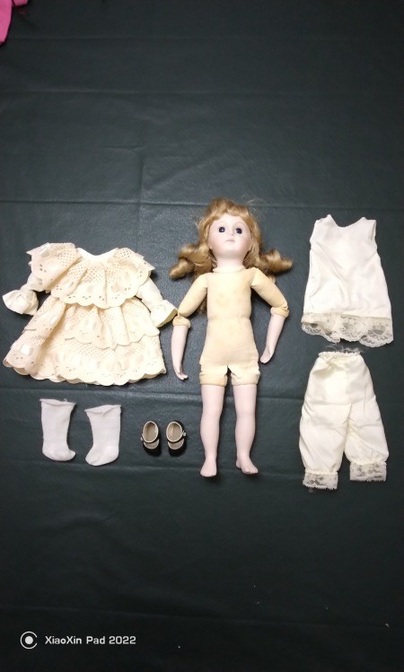 A vintage doll with accessories.