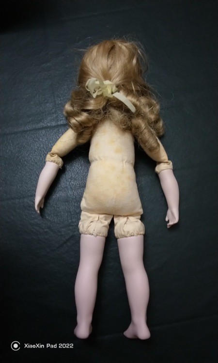 The back side of the undressed doll.