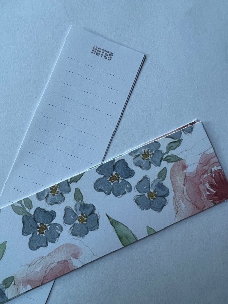 Assembling a long and skinny notepad.