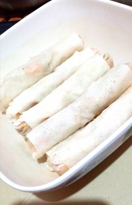 Several rolls in a dish, before frying.