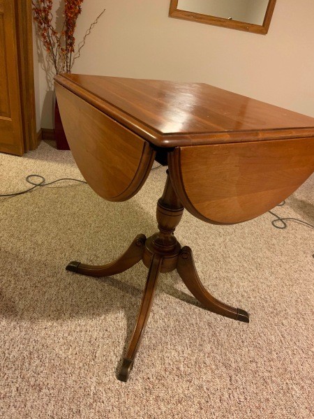 A wooden end table with folding leaves.