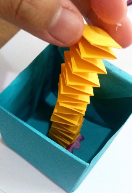 Attaching the accordion fold to the inside of the box.