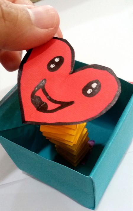 Attaching the heart to the accordion folded paper.