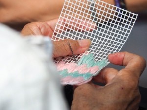 A plastic canvas project with yarn being worked on.