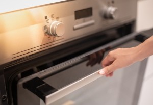 A person opening an oven door.