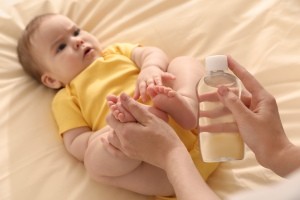 A baby and mother using baby oil.