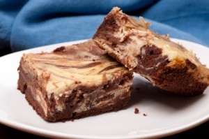 A plate with two cream cheese brownies.