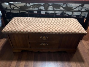 A cedar chest with a padded top.