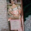 A porcelain doll wearing a wedding dress in a box.