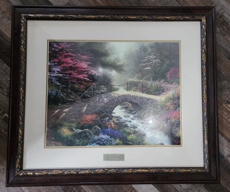 A framed Thomas Kincade print.