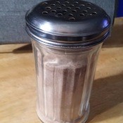 A shaker with cinnamon and sugar.