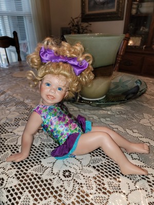 A porcelain doll in a colorful outfit.
