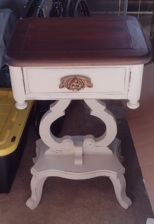 A small side table, painted white.