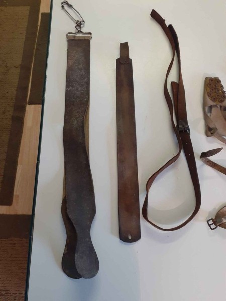 A collection of leather hand farm tools.
