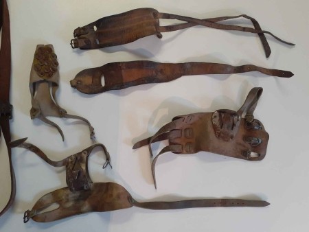 A collection of leather hand farm tools.