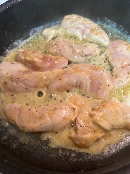 Cooking the chicken in a pan.