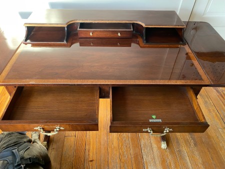 The wooden desk with the drawers open.