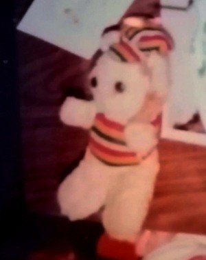 A teddy bear wearing a striped outfit.