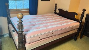 A wooden four poster bedstead.