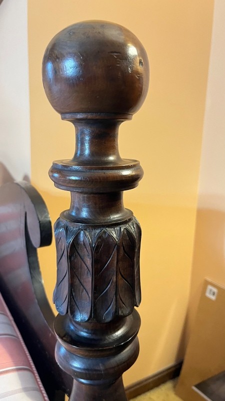 The wooden post of a bedstead.