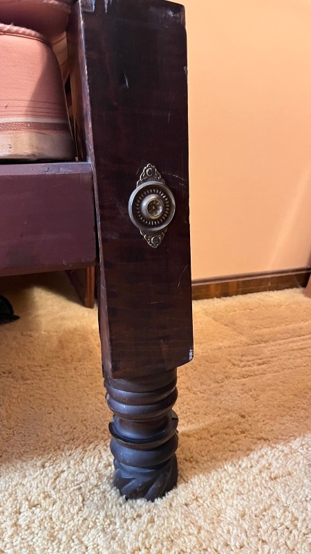 A decorative element on the leg of a bed.
