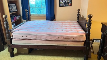 A wooden four poster bedstead.