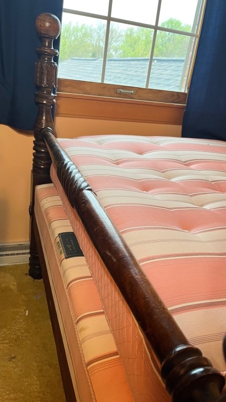 The foot of a wooden bed.