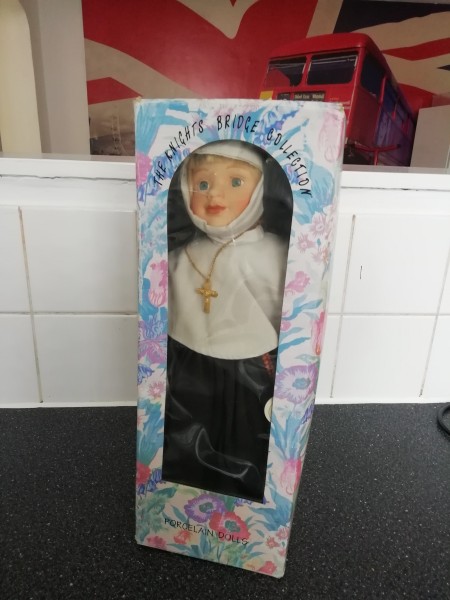 A porcelain nun doll in the box.