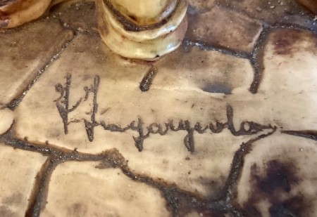 Close up of an artist's signature on figurine.