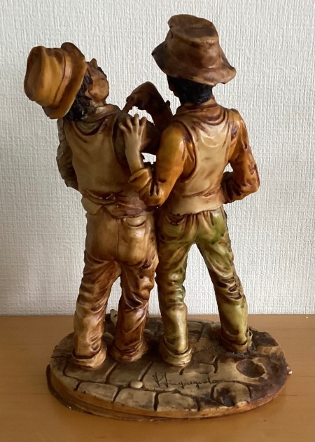 Back of figurine of two men.