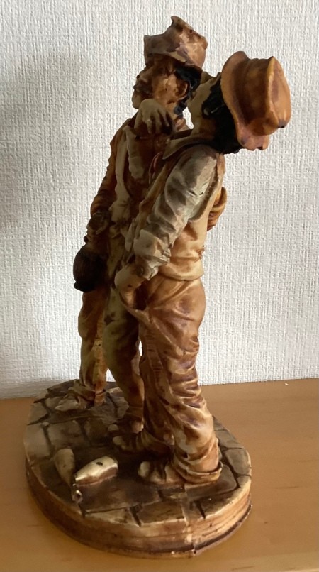 Side view of figurine of two men.
